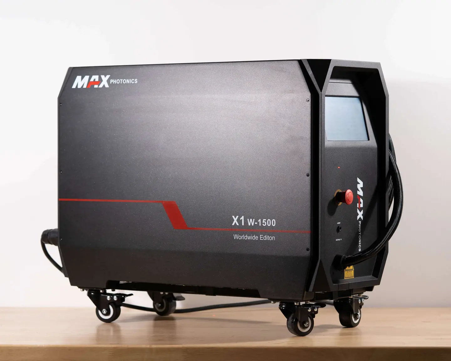 Ein schwarzes, rollbares Gerät mit der Beschriftung "MAX PHOTONICS X1 W-1500 Worldwide Edition" steht auf einem Tisch.